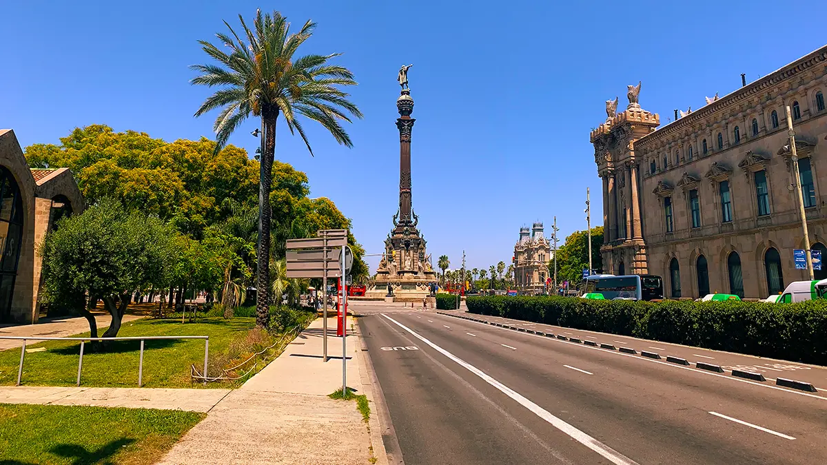 View of the Columbus Monument and palm trees along the wide avenue on the Barcelona Gothic Quarter & Coast Bike Tour.
