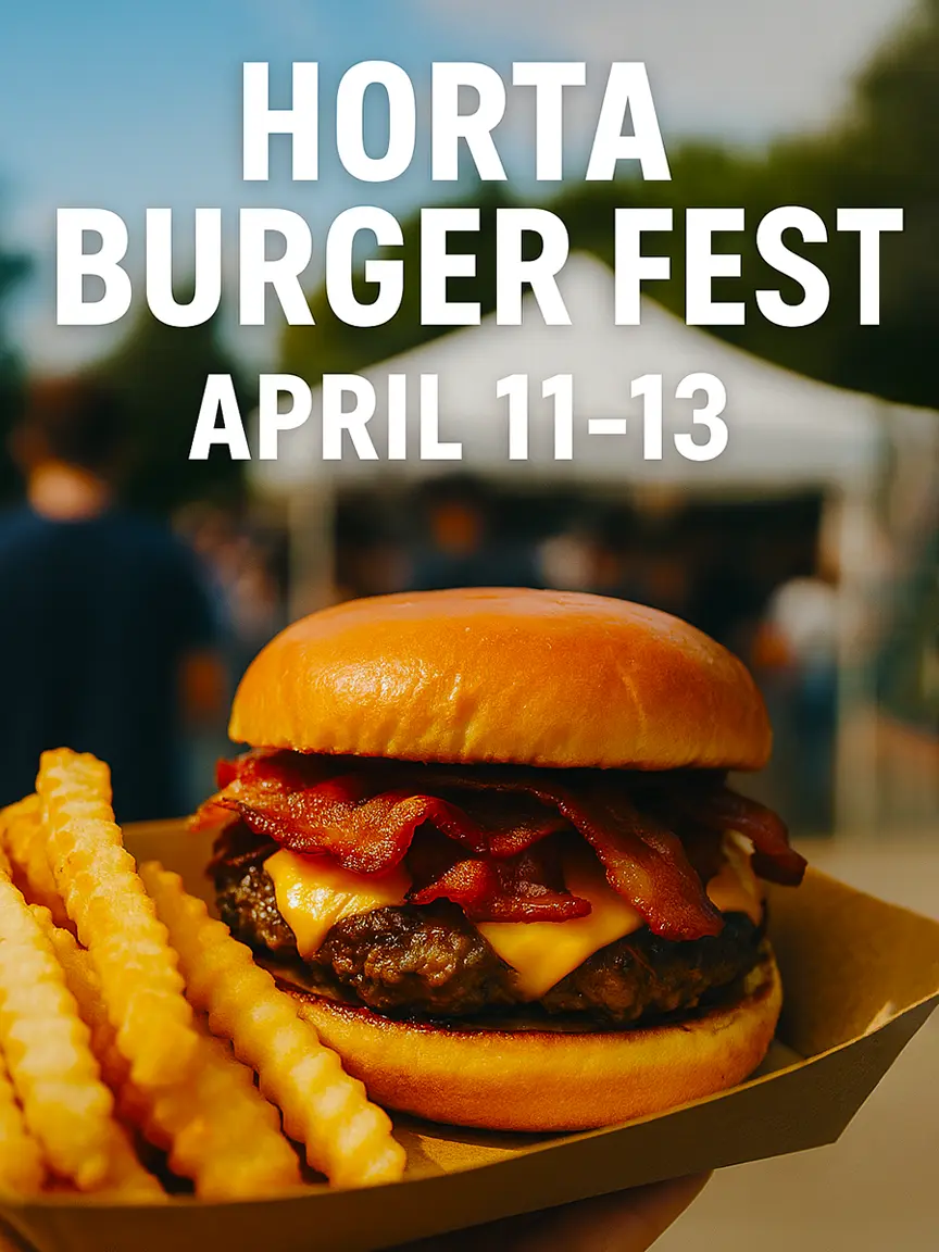 A close-up of a delicious burger with bacon, cheese, and a beef patty, served with crinkle-cut fries in a tray at Horta Burger Fest 2025. The background shows a blurred crowd, capturing the lively atmosphere of the festival held on April 11-13.